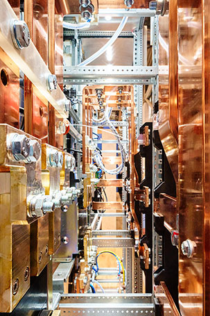 Blick in das Innere eines großen Transformators, mit großen Kupferstreben und Stahlschrauben (Messefotografie)